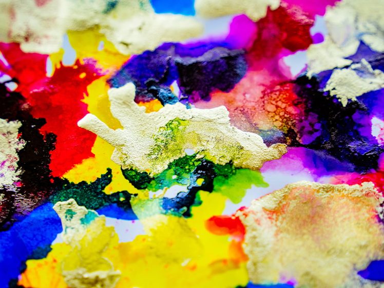 Image of Abstract watercolour painting featuring vibrant splashes of red, yellow, blue, green, and purple, with textured areas of thick white and gold paint scattered across the colourful background.