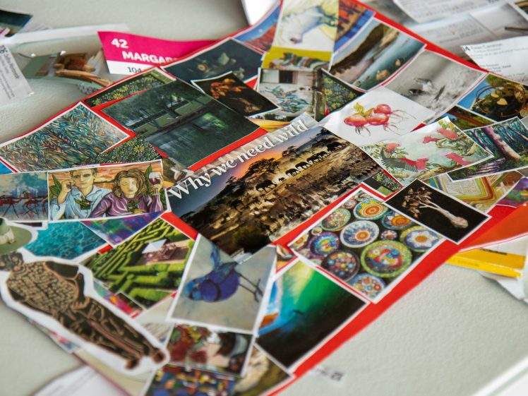 Image of A collage of assorted colourful images and artwork pieces is spread out on a table, with some papers and documents partially visible underneath.