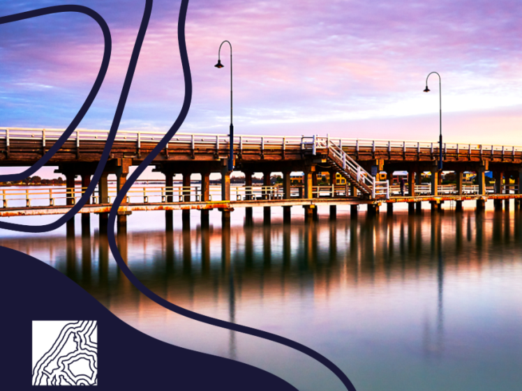 Image of A wooden pier extends over calm water at sunset with street lamps lining the bridge. The sky is purple and orange. Mandurah Open Studios text and a wavy line graphic appear in the bottom left corner.